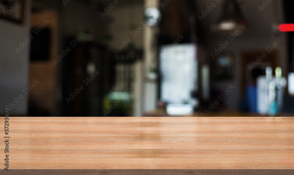 Empty wooden table with blurred cafe and coffee shop interior background