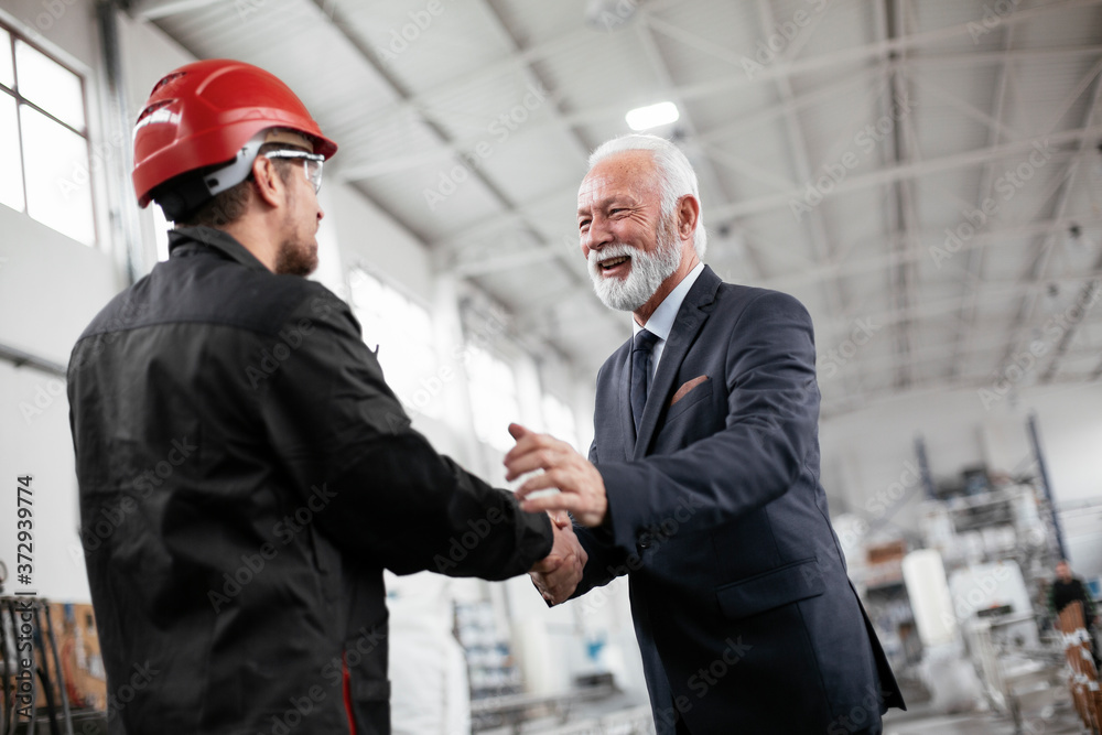 Colleagues working together. Arhitect and worker handshake in factory.. Colleagues working together. Arhitect and worker handshake in factory..