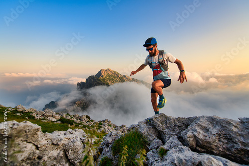 Man ultramarathon runner in the mountains he trains at sunset photo