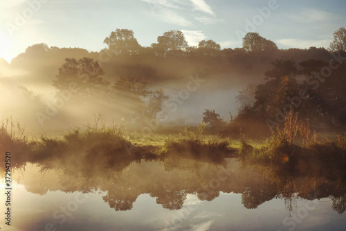 Early morning mist over the meadows on the River Wey in Godalming, Surrey, on a cold autumn morning.