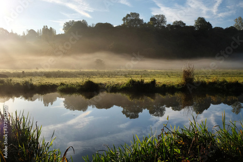 Early morning mist over the meadows on the River Wey in Godalming, Surrey, on a cold autumn morning.