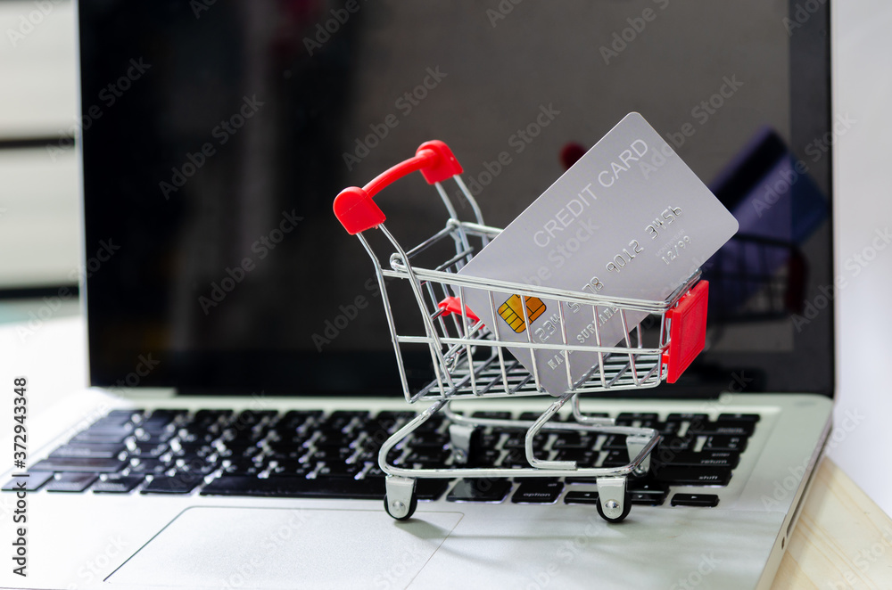 Credit card on the cart at the computer laptop