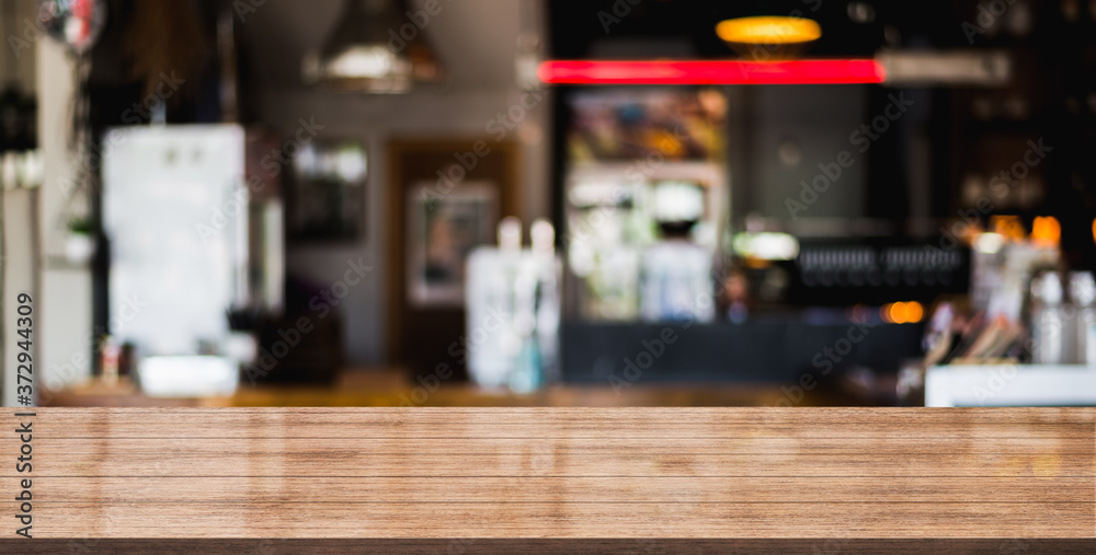 Empty wooden table with blurred cafe and coffee shop interior background