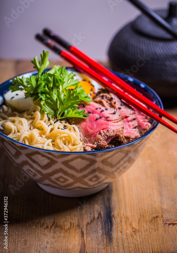 Ramen Soup with Wagyu Beef Filet on Bowl on wooden table. Beef ramen served in Asian style photo