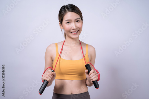 Asian woman holding rope skipping equipment isolated on white background, Healthy exercise ideas.