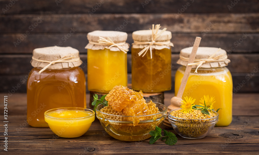 Fresh honey in the bowl and jars, with honeycomb and bee pollen Fresh honey in the bowl and jars, with honeycomb and bee pollen