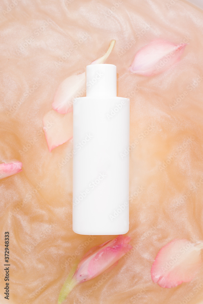 Mockup of cosmetic products. White bottle in shiny water with flowers Mockup of cosmetic products. White bottle in shiny water with flowers