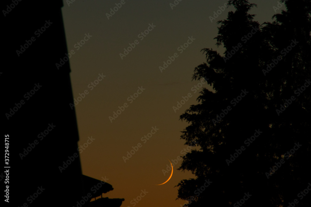 the crescent moon rising in the evening