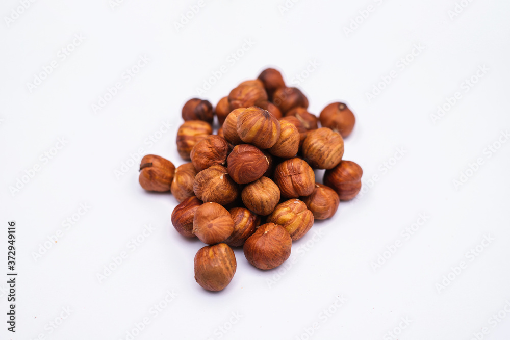 Whole hazelnut kernels lie on a white background. The autumn harvest. Whole hazelnut kernels lie on a white background. The autumn harvest.