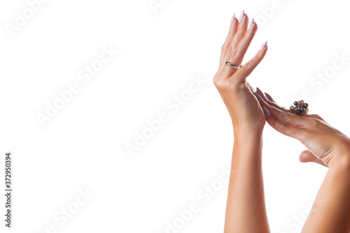 Graceful female hands with jewelry on a white background