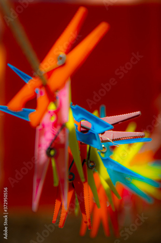 Coloured plastic clothespins fastened on a rope with the background out of focus