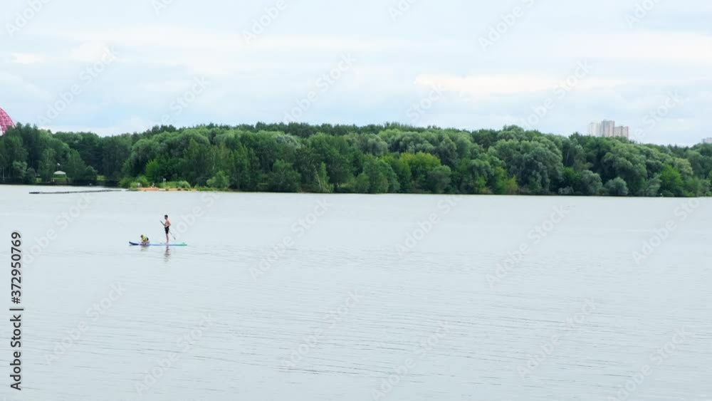 View of the man standing firmly on the SUP inflatable board View of the man standing firmly on the SUP inflatable board