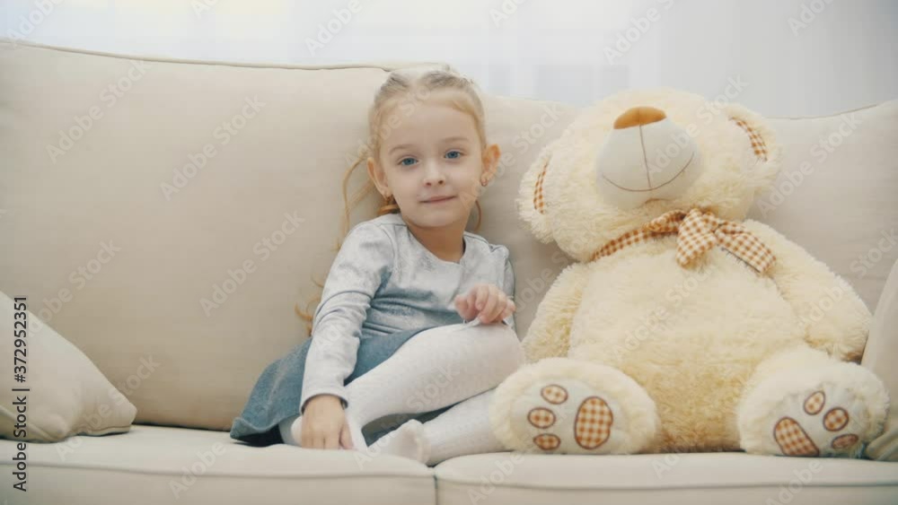 4k video of cute little girl sharing secrets with her teddy bear and smiling. 4k video of cute little girl sharing secrets with her teddy bear and smiling.