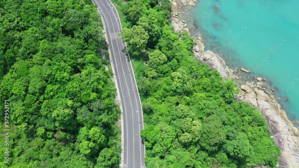 Aerial view of road between coconut palm tree and great ocean at daytime in Nakhon Si Thammarat, Thailand Aerial view of road between coconut palm tree and great ocean at daytime in Nakhon Si Thammarat, Thailand