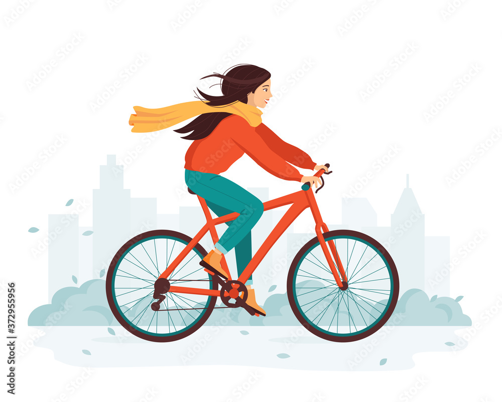 Obraz premium Young happy woman rides a bicycle in the autumn city. The concept of outdoor activity and healthy lifestyle in the fall. Cold season. Eco-friendly transport, vehicle. Cute cartoon vector illustration