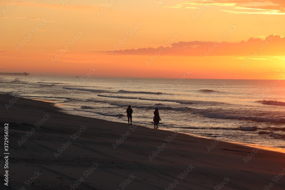 silhouette of a people walking on the beach
