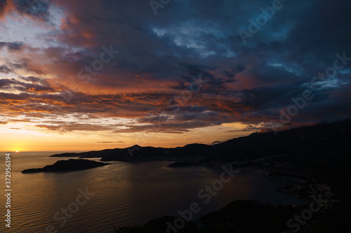 Fiery red and blue sky during sunset over the Budva Riviera in Montenegro and the island of St. Nicholas.