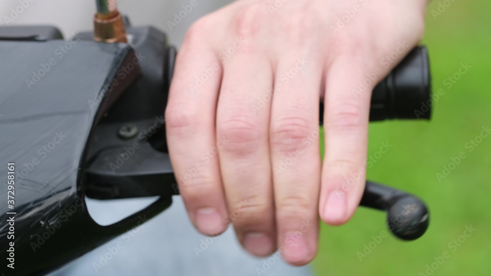 Brake handle on moped. Hand close up