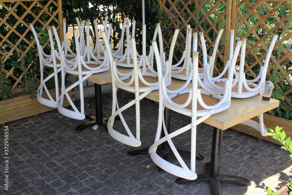 Greece, Athens, June 17 2020 - Chairs stacked outside of a traditional restaurant in the touristic district of Monastiraki. Greece, Athens, June 17 2020 - Chairs stacked outside of a traditional restaurant in the touristic district of Monastiraki.