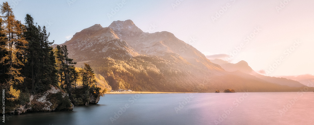 Yellow larches and alpine lake in fall, Swiss alps