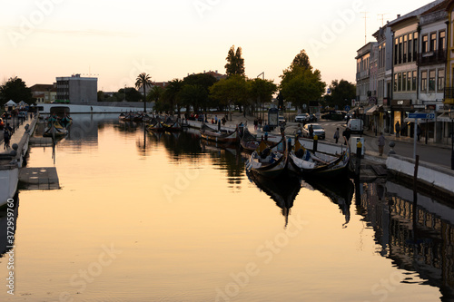 Urban river with gondolas in front of historical buildings during sunset