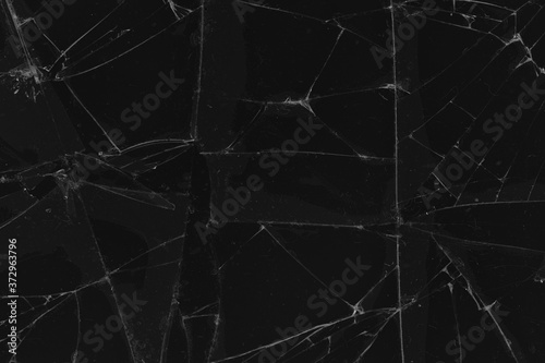 Black cracked glass texture background. Crack on the glass. Broken screen. Broken dark phone.  White cracks in glass © Илья Подопригоров