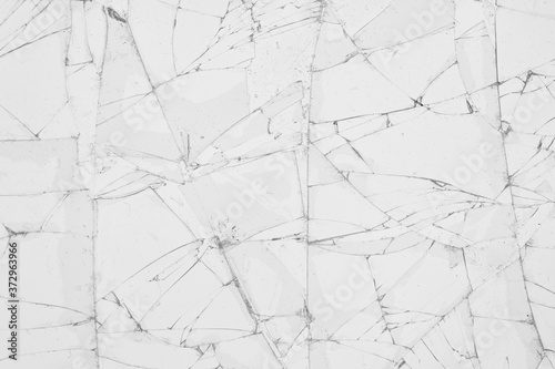 White cracked glass texture background. Texture broken glass window with cracks. Broken screen.