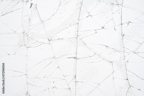 White cracked glass texture background. Texture broken glass window with cracks. Broken screen.