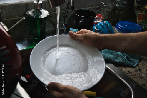 Fotografie Washing dishes because in quarantine, dirty dishes do not stop.