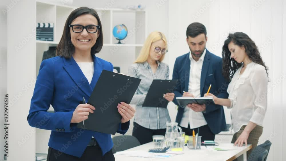 4k slowmotion video of female director standing in front of her collegues.