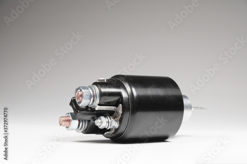 Starter solenoid for car on gray background. Auto parts photo