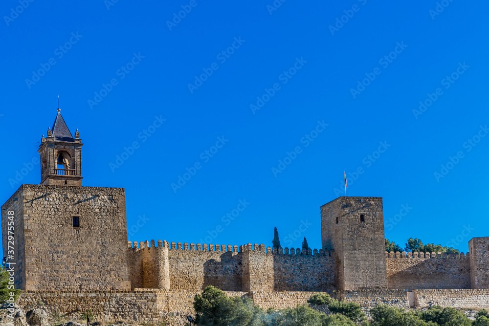 Tower of the Homenaje or clock Pabellonotas and the Torre Blanca with its fortress at the Alcazaba de Antequera, sunny day with a blue sky in the province of Malaga, Spain