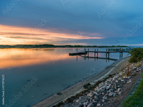 Lagoon landscape at dawn with wooden jetty