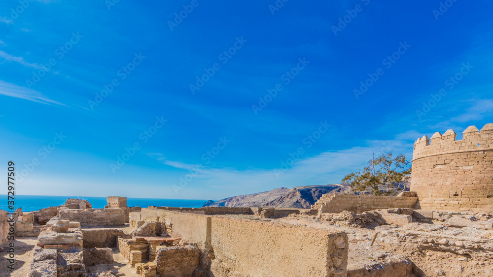 Part of the ruins of the Alcazaba in Almeria on a wonderful sunny day and a blue sky with the sea in the background in Spain