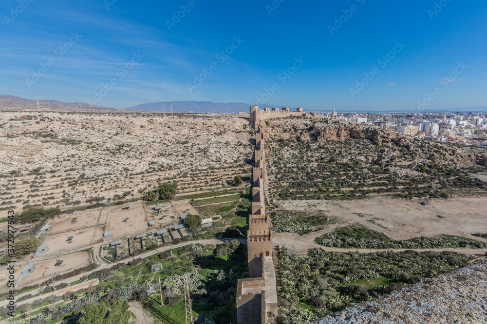 View of the Alcazaba with its towers and walls in a rocky and arid terrain, wonderful sunny day with a blue sky in Almeria Spain