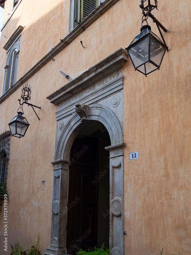 Paisaje urbano con una puerta y dos farolas en la fachada, en Spoleto, Italia, verano de 2019.