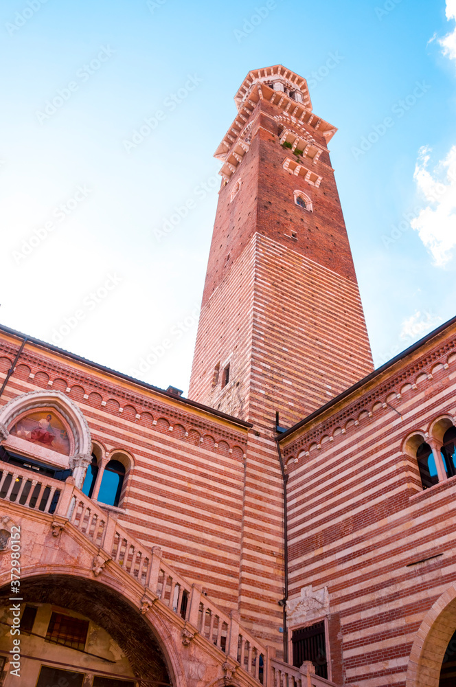 Red brick courtyard of medieval Palazzo della Ragione with Lamberti Tower located in Verona, Italy.