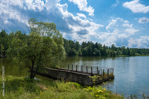 A spillway to a reservoir with a beautiful cloudy sky on a summer day. © Valery Smirnov