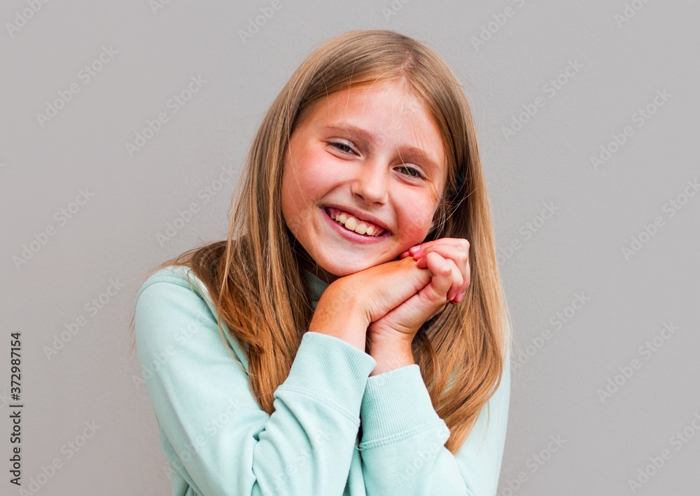 Portrait of happy smiling child girl isolated on gray background Portrait of happy smiling child girl isolated on gray background