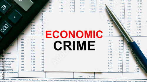 Work smarter text Economic Crime on white sheet with pen, calculator and tables