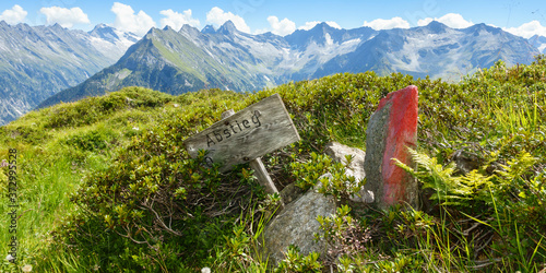 Panoramabild Holztafel als Wegweiser zum Abstieg ins Tal photo