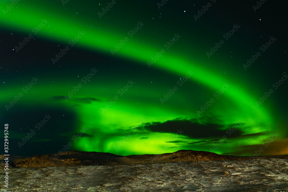 Northern lights in the night sky of iceland. Soft focus. Magical green glow. Northern lights in the night sky of iceland. Soft focus. Magical green glow.
