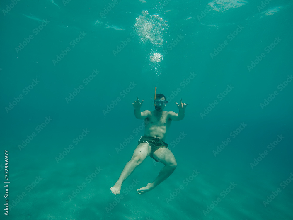 Young boy diving under the sea.