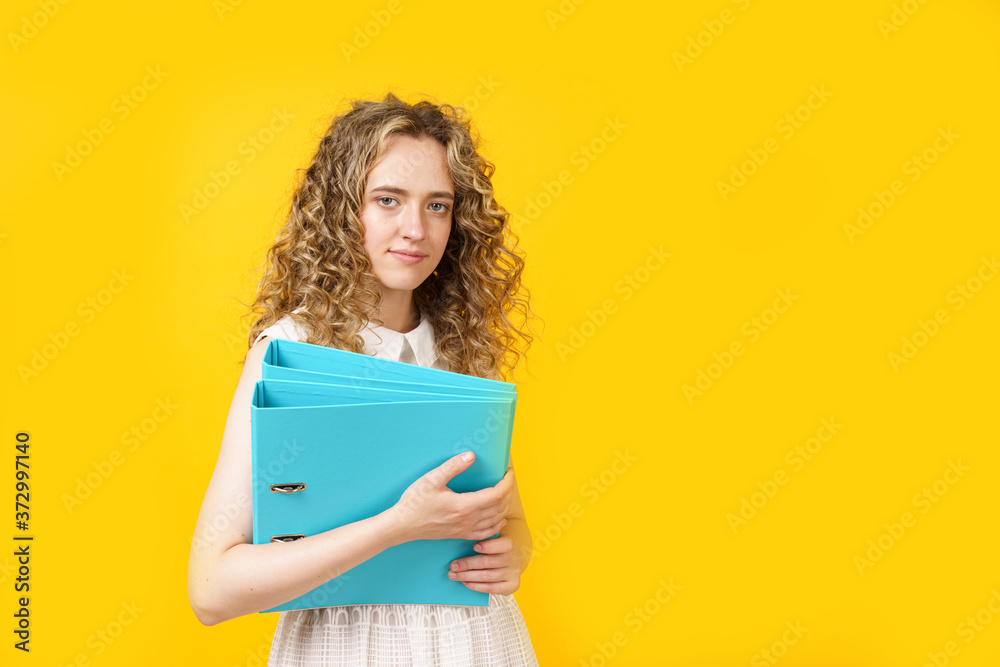 A young woman holds folders with documents in her hands. A young woman holds folders with documents in her hands.