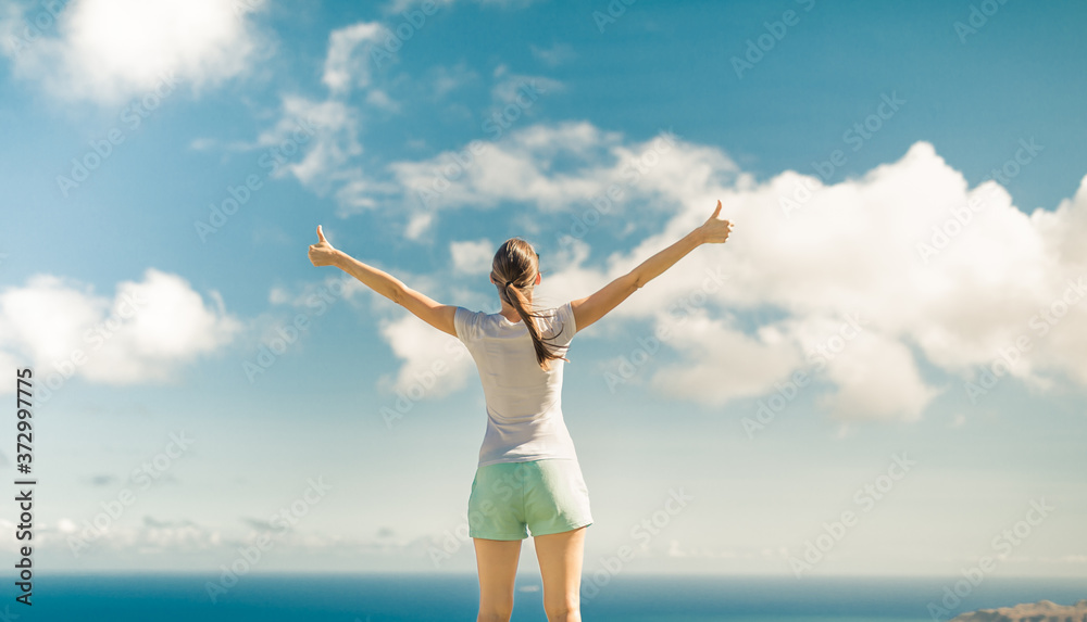 Happy young female outdoors living in a healthy state of mind with thumbs up in the sky. Happy young female outdoors living in a healthy state of mind with thumbs up in the sky.