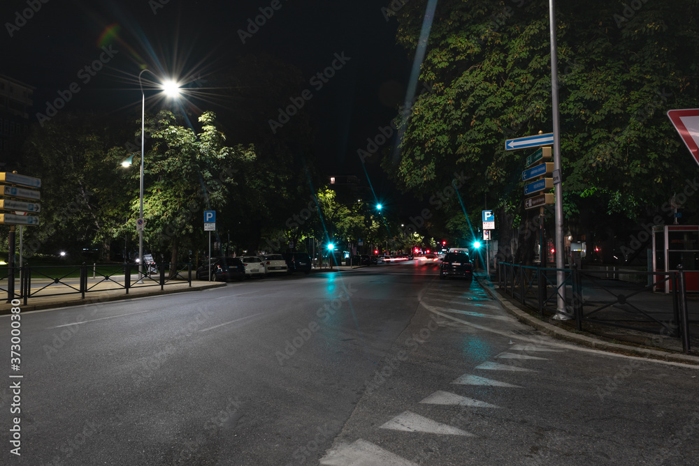 Fototapeta premium Timelapse view of traffic at an urban night intersection. Urban movement in the Italian city in the evening. Traffic lights. Time Lapse. 4K video