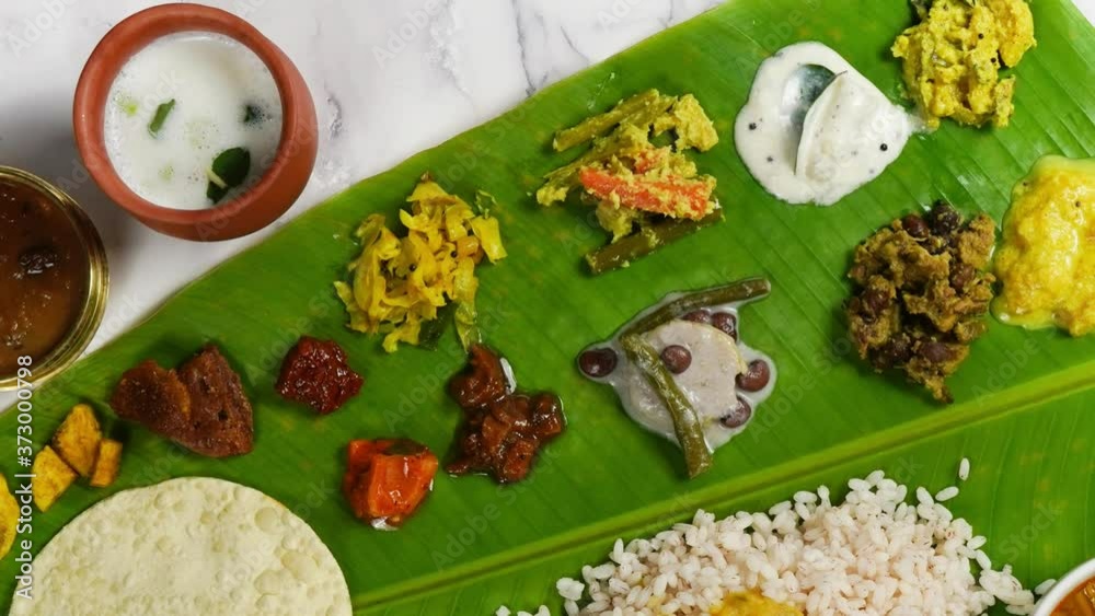 Traditional Kerala Onam feast / Sadya served on a banana leaf  