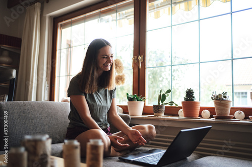 Free Download Cheerful European woman video conferencing with friend on laptop at home - GFXLoad