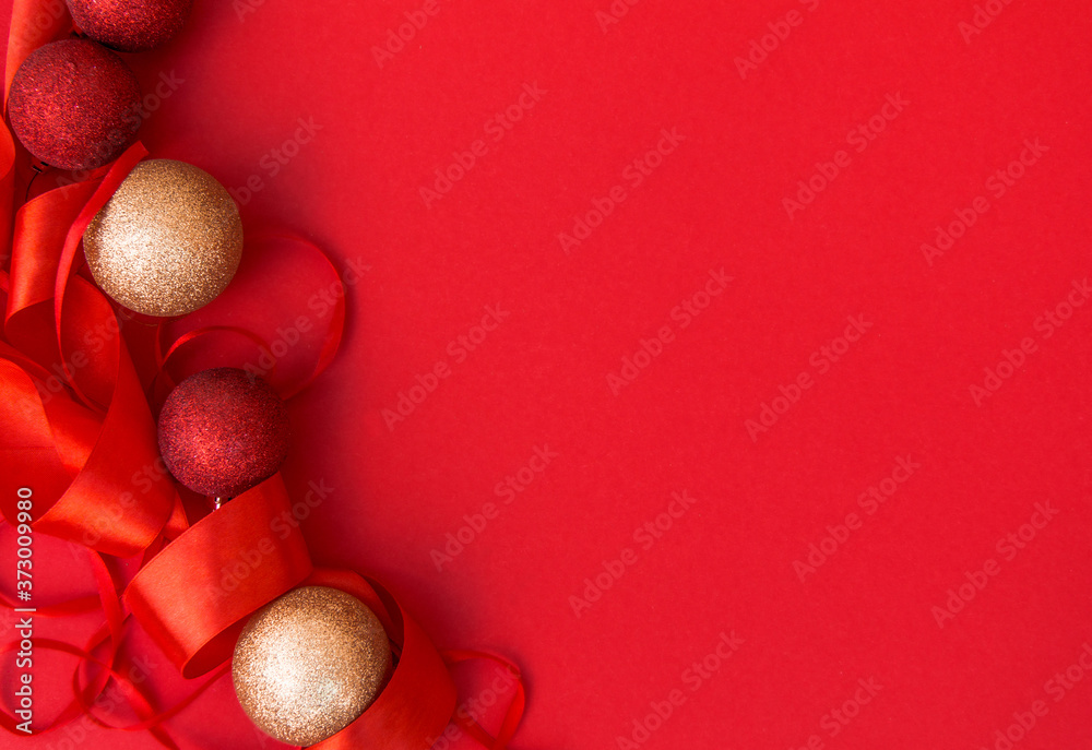 The concept of New year and Christmas. Red and gold Christmas balls on a red background, red ribbon