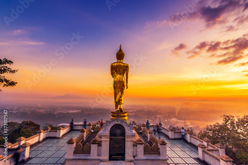 Golden buddha statue in Khao Noi temple at sunrise, Nan Province, Thailand photo